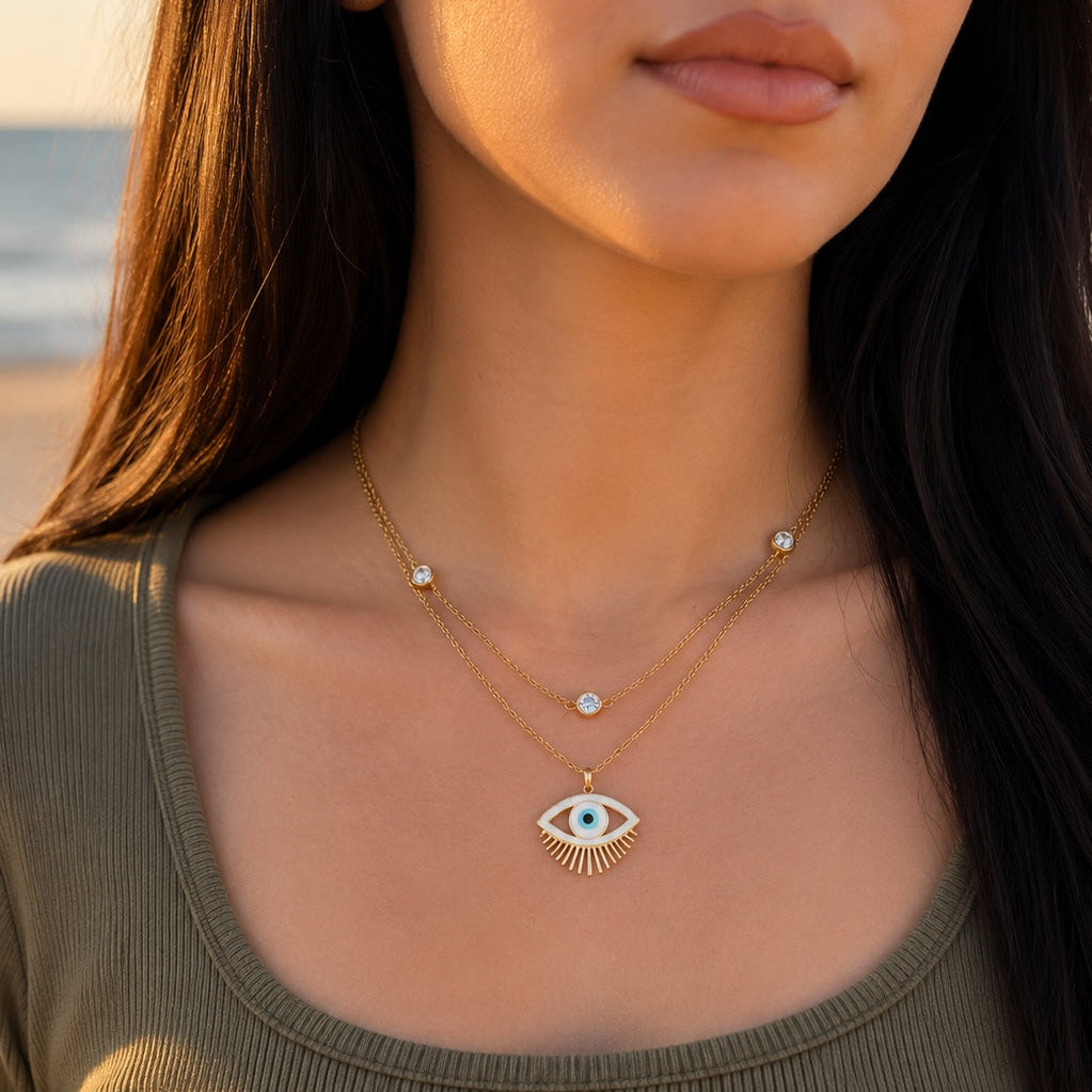 Woman wearing a gold necklace with an eye design outdoors