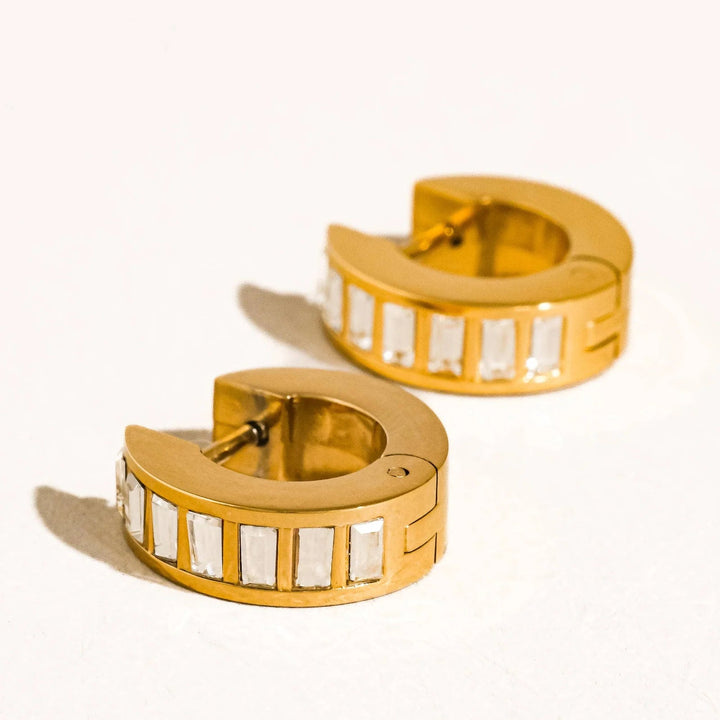 Gold hoop earrings with embedded stones on a white background