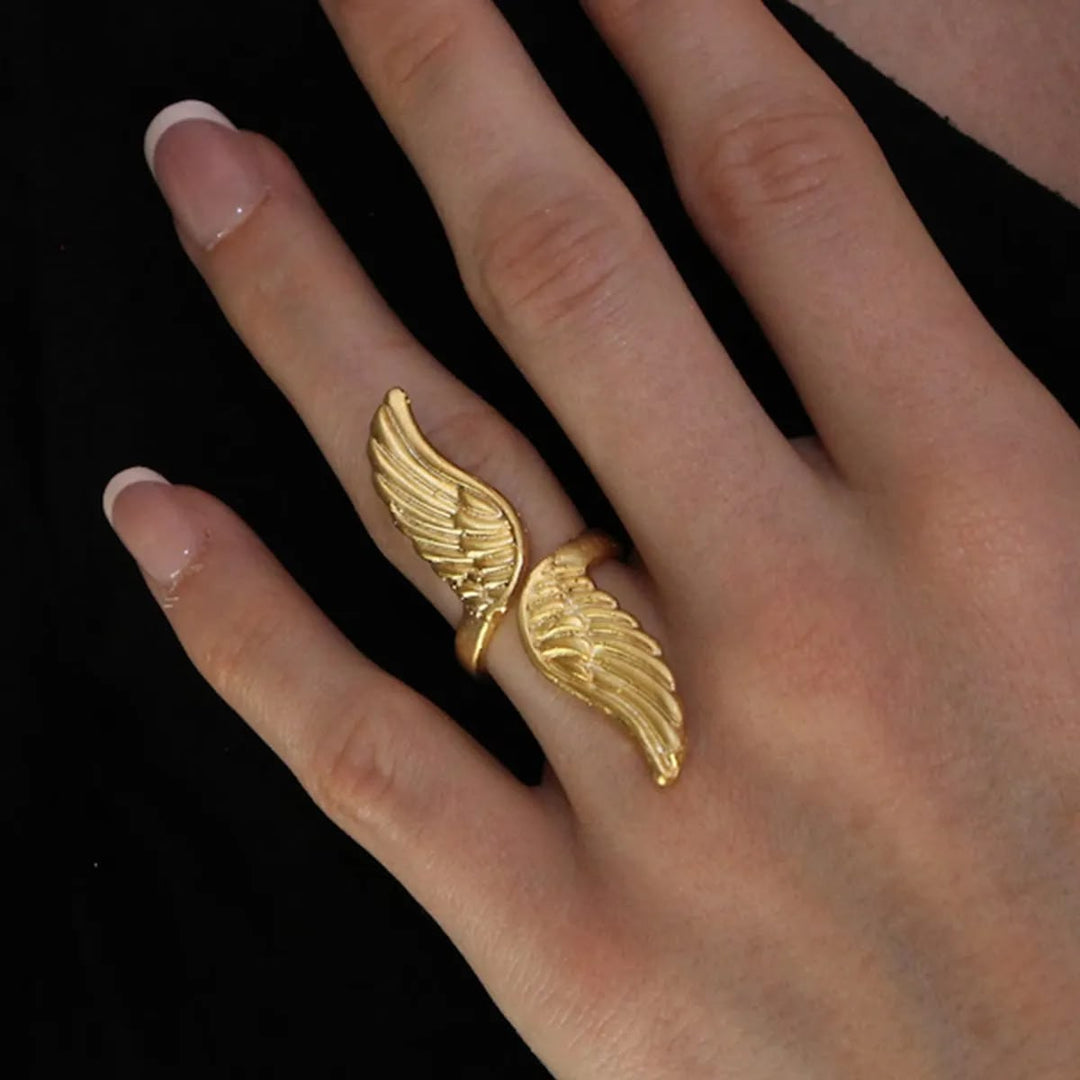 A gold wing-shaped ring worn on a person&