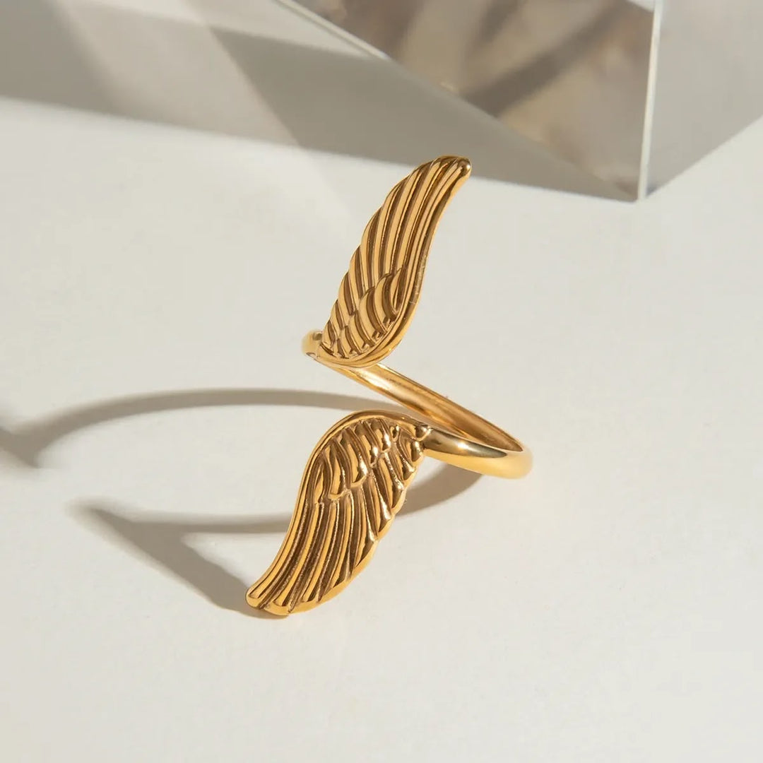 Gold wing-shaped bracelet on a light background