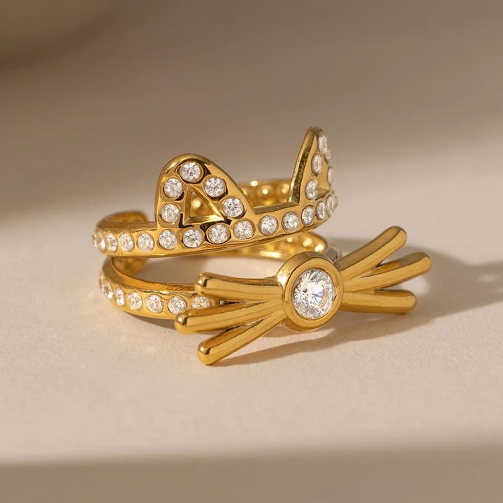 Two gold rings with diamond accents on a beige background
