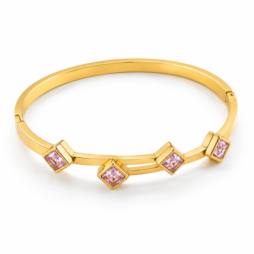 A polished yellow gold hinged bangle bracelet featuring four small square bezel-set light pink gemstones, displayed on a clean white background.