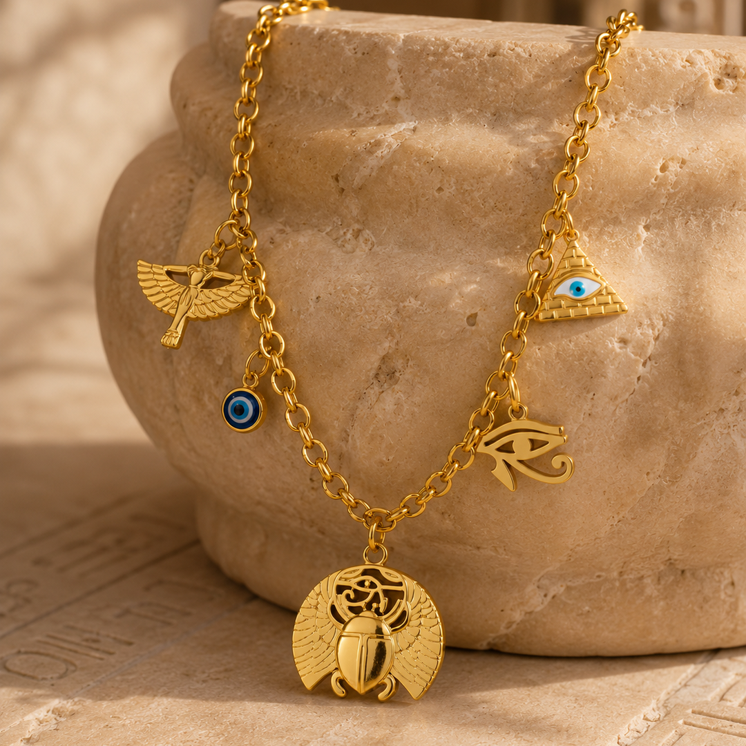 Gold necklace with various charms on a stone surface