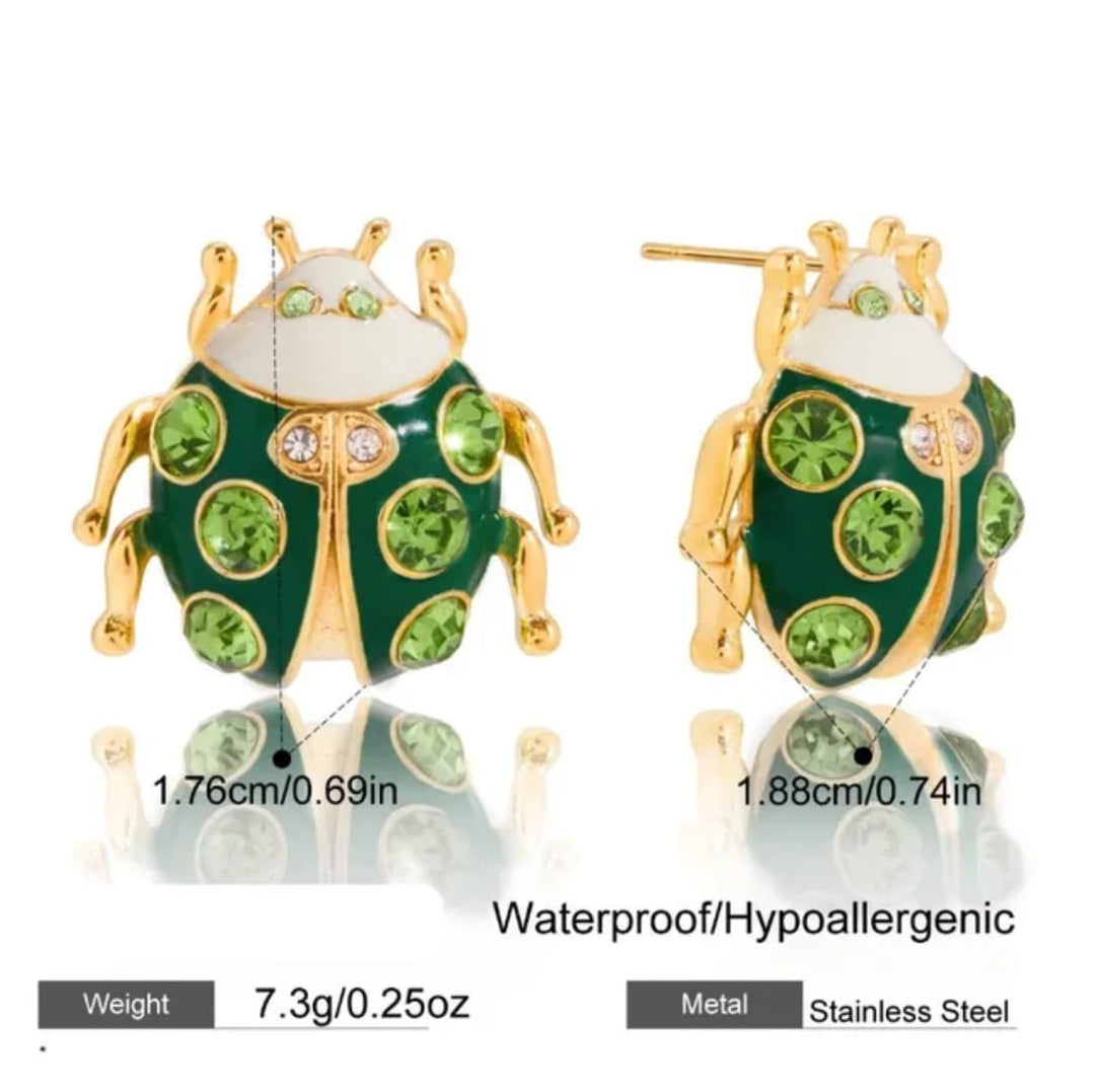 Two green ladybug-shaped stud earrings with gold-tone metal outlines and green rhinestones, shown front and back on a white background with size, weight, and &