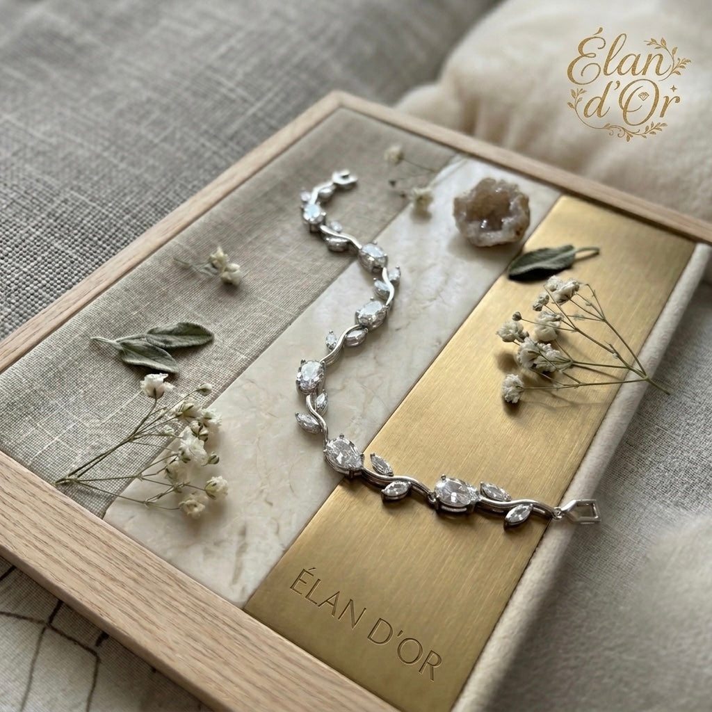 Silver bracelet on a wooden box with dried flowers and leaves, branded &
