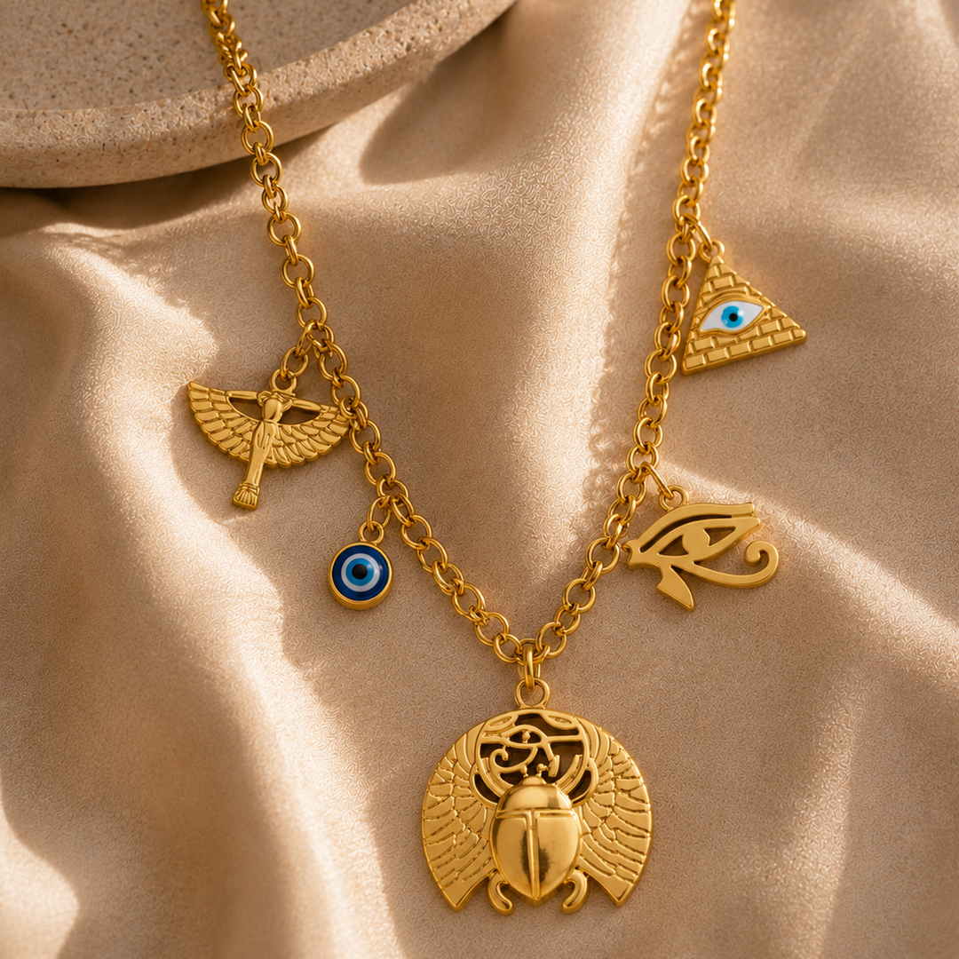 Gold necklace with various charms on a beige fabric background