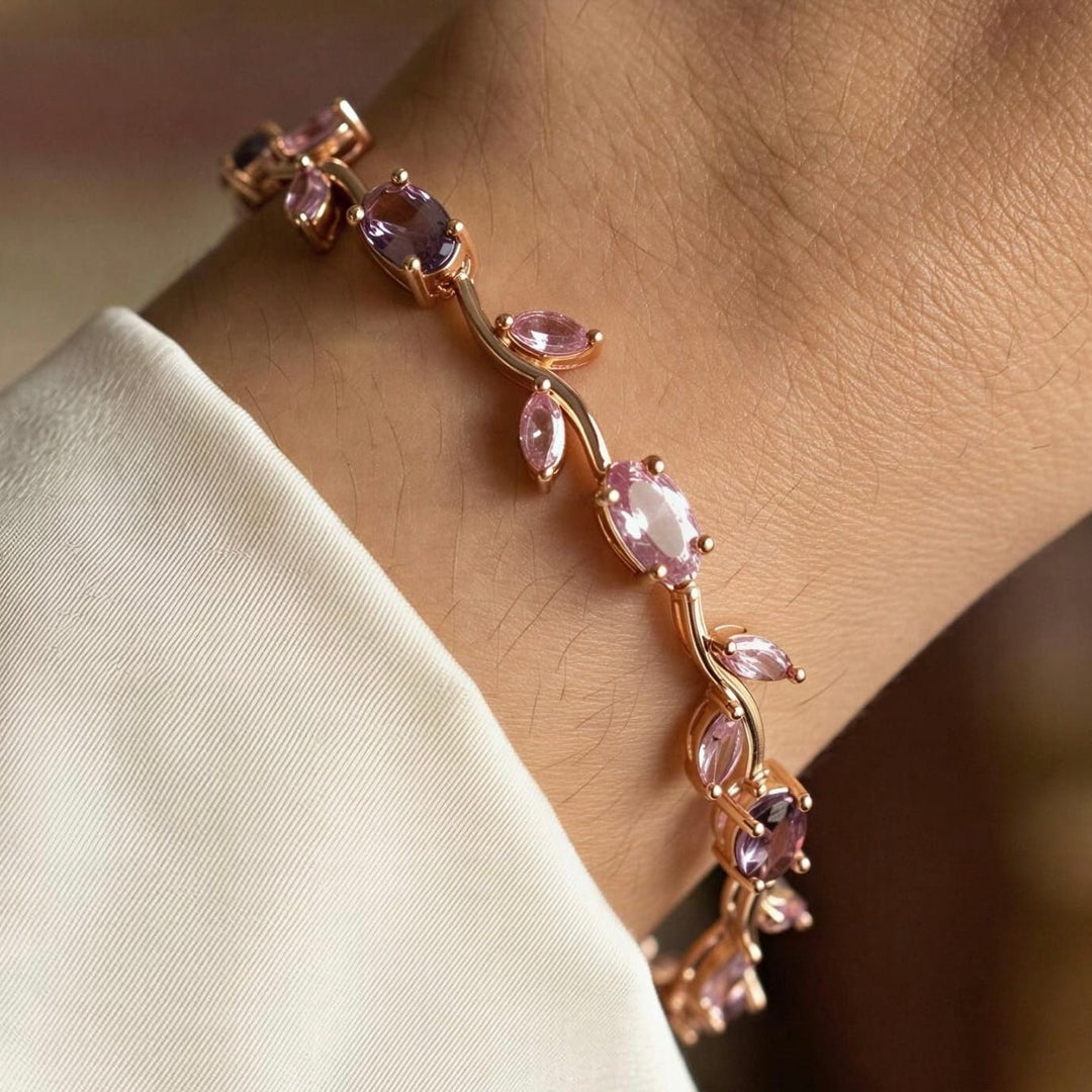 Close-up of a bracelet with pink gemstones on a wrist against a blurred background