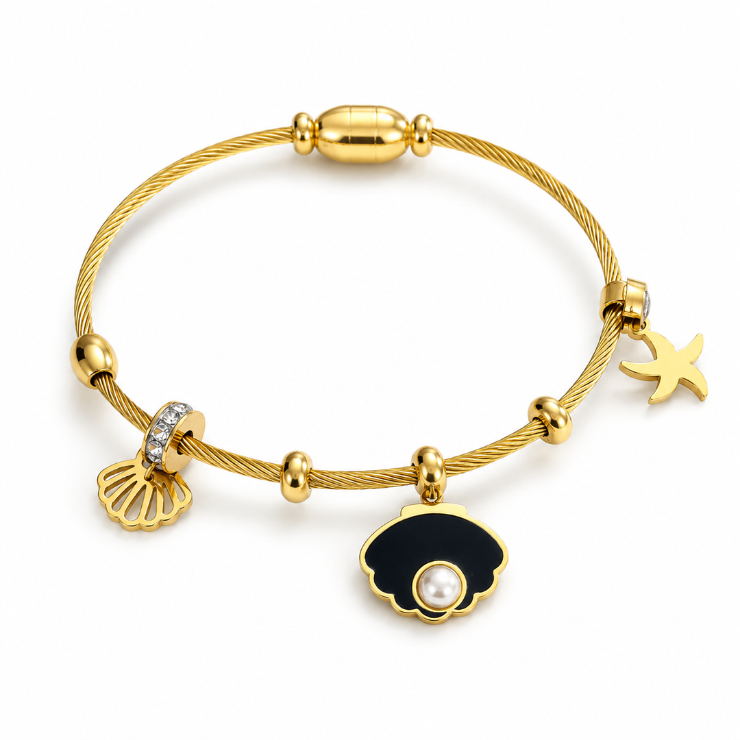 A gold cable-wire charm bracelet featuring a black and white pearl shell charm, a gold seashell charm with clear rhinestones, and a gold starfish charm, displayed on a clean white background.