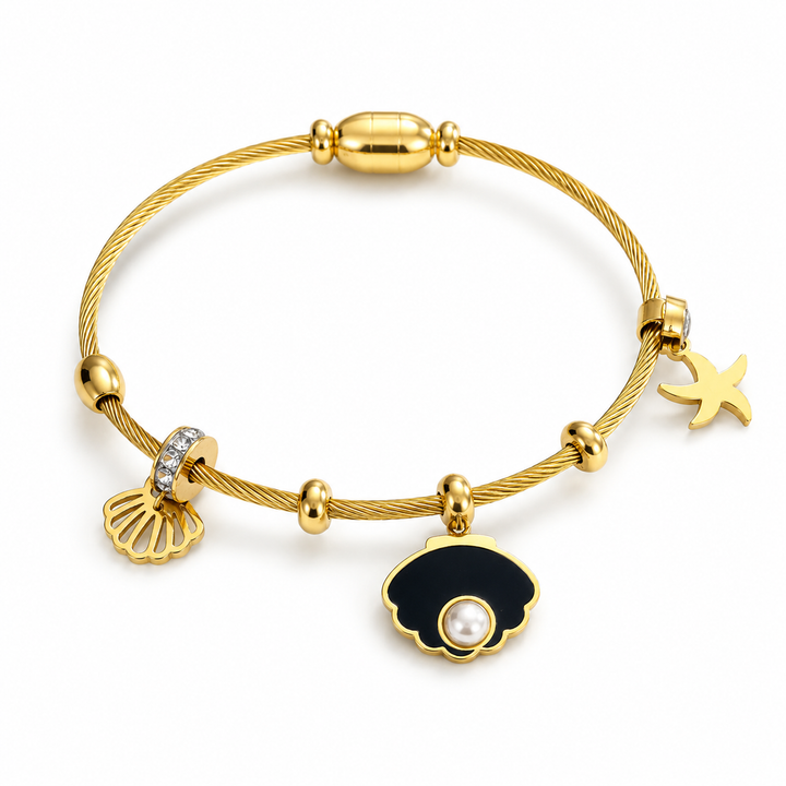 A gold cable-wire charm bracelet featuring a black and white pearl shell charm, a gold seashell charm with clear rhinestones, and a gold starfish charm, displayed on a clean white background.