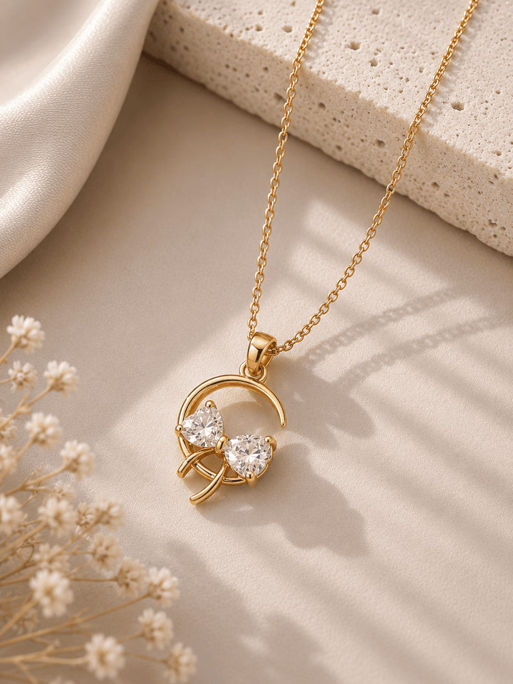 Gold necklace with a heart-shaped pendant on a neutral background