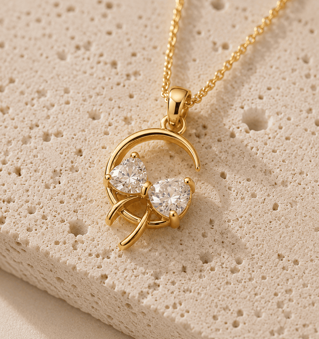 Gold necklace with a pendant on a textured beige surface