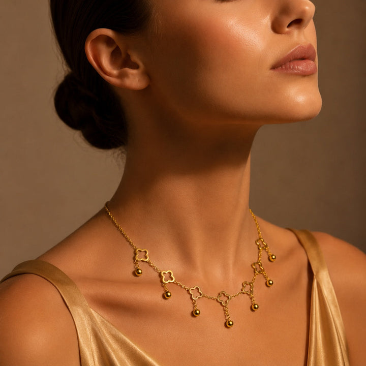 Woman wearing a gold necklace against a brown background