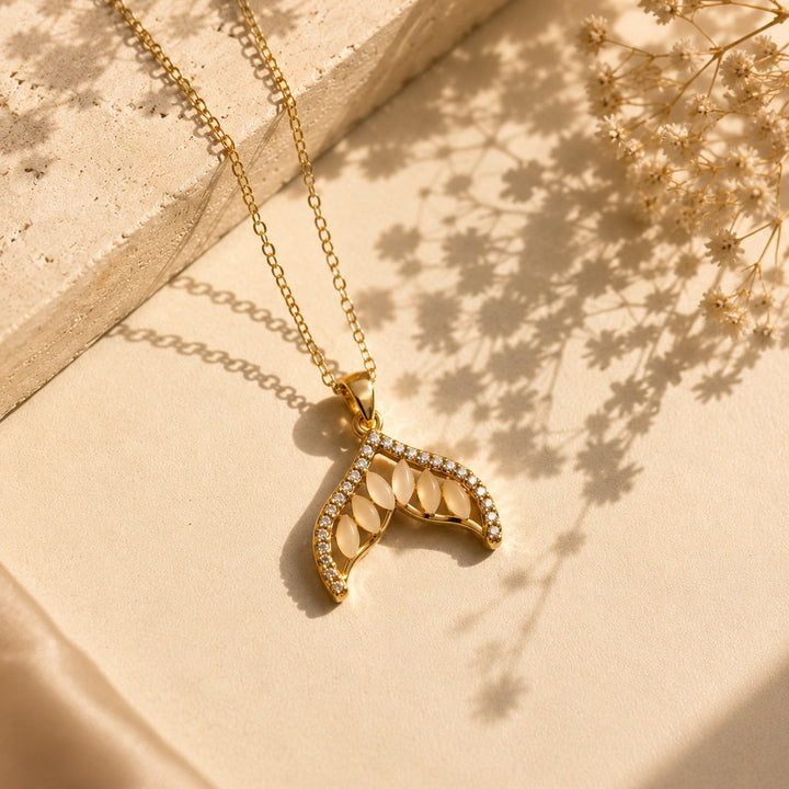 Gold necklace with a unique pendant on a beige fabric background