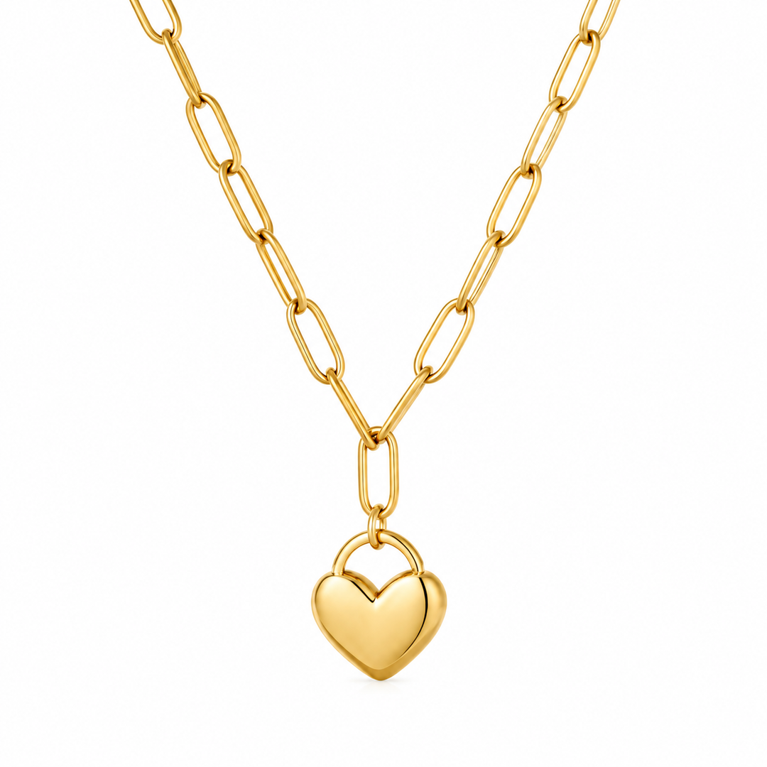 A gold paperclip chain necklace with a small, polished gold heart pendant, shown against a plain white background.