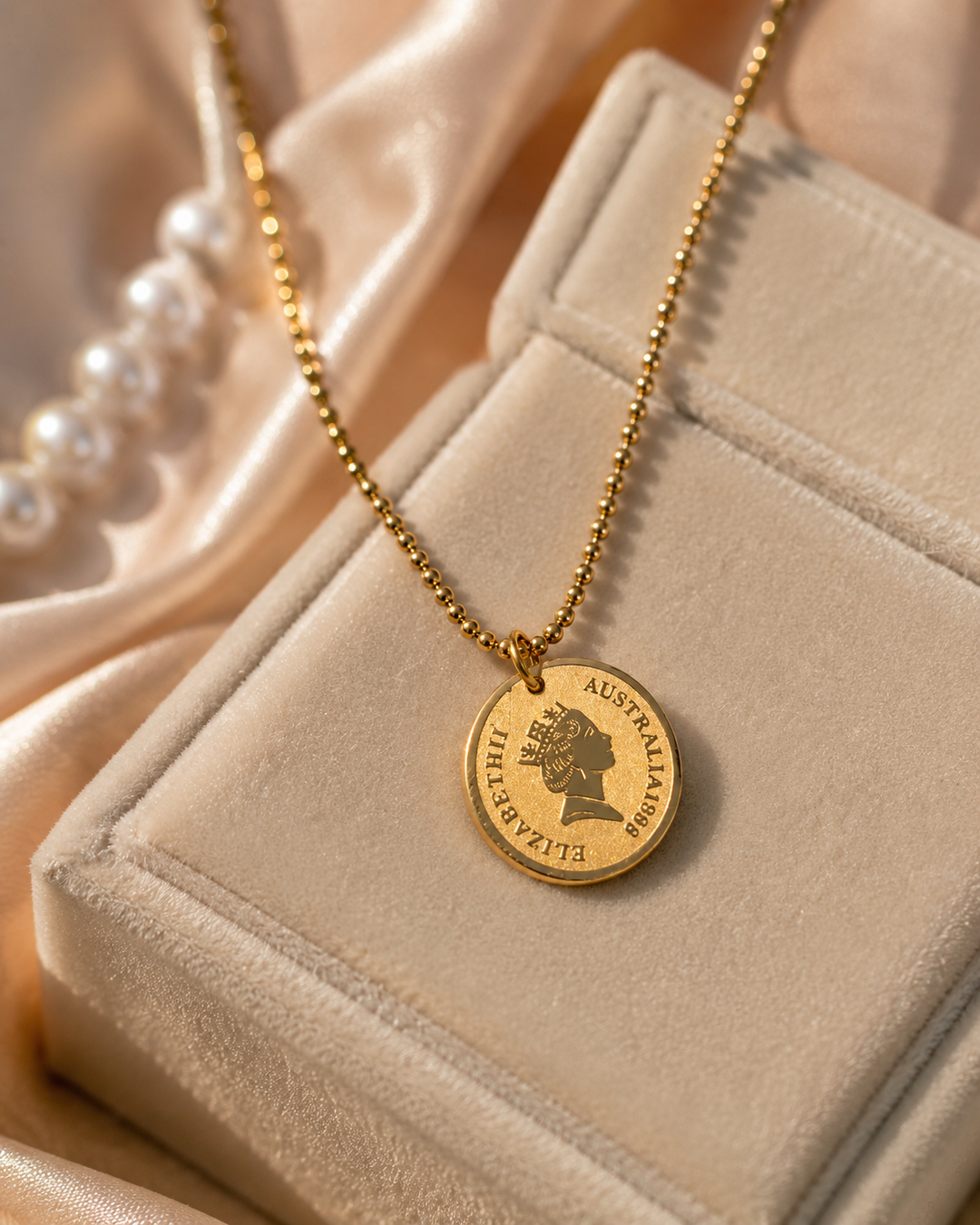 Gold necklace with a pendant on a beige jewelry box