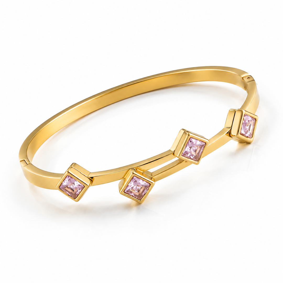 A gold-plated bangle bracelet with three square bezel-set light pink gemstones, displayed on a clean white background.