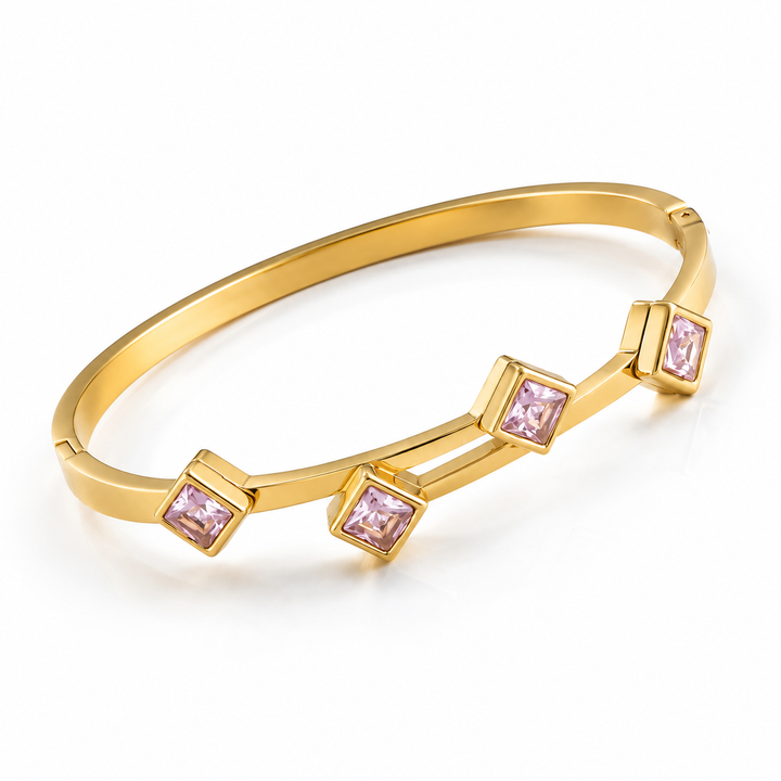 A gold-plated bangle bracelet with three square bezel-set light pink gemstones, displayed on a clean white background.