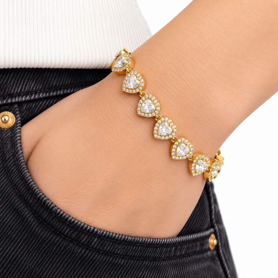 A gold bracelet with seven teardrop-shaped clear gemstone clusters, shown worn on a person&