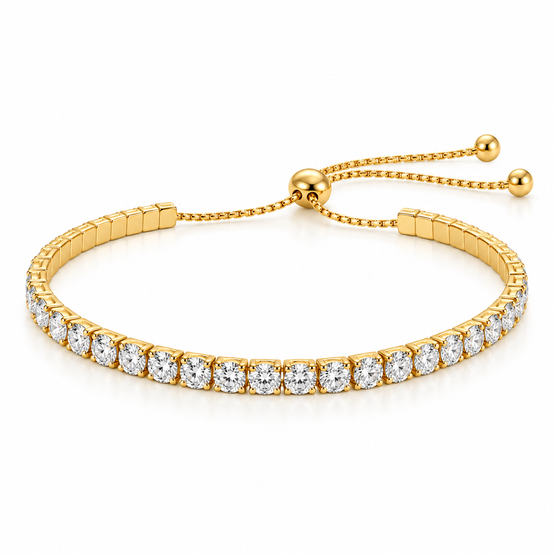 A gold-plated tennis bracelet adorned with round-cut clear gemstones, featuring an adjustable sliding clasp with a beaded chain and ball slider, set against a clean white background.