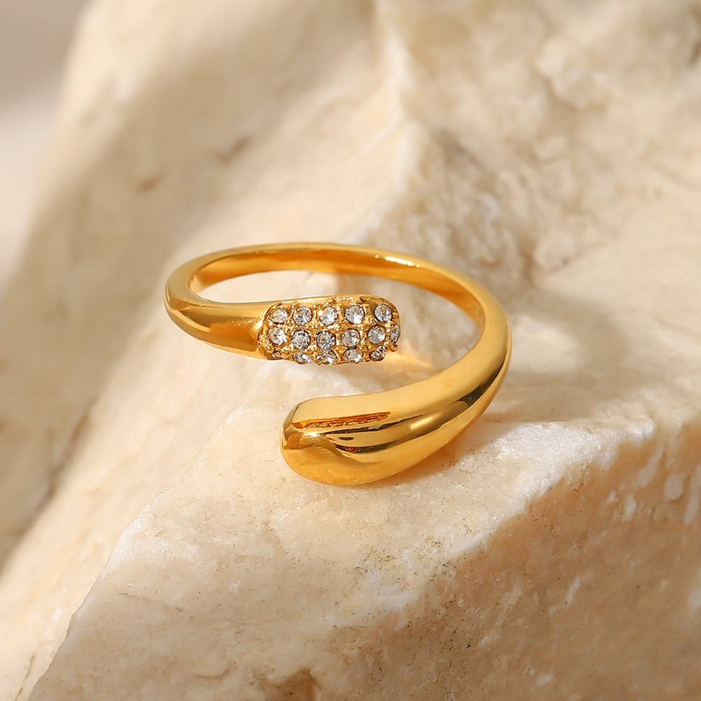 Gold ring with gemstones on a beige stone background