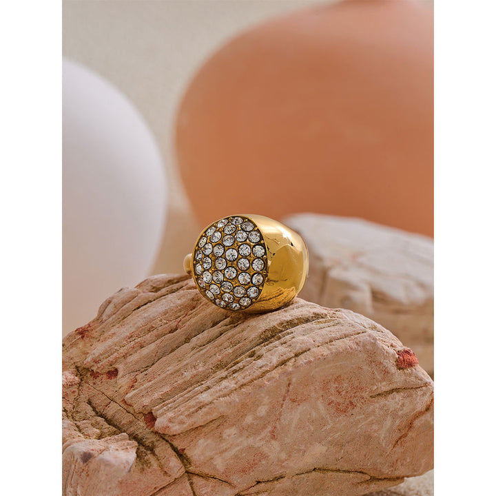 Gold ring with gemstones on a textured surface