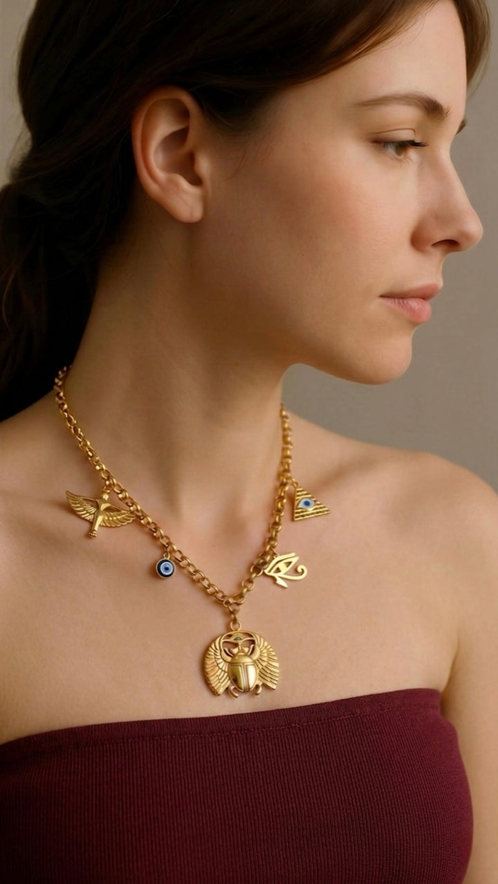 Woman wearing a gold necklace with various pendants against a neutral background