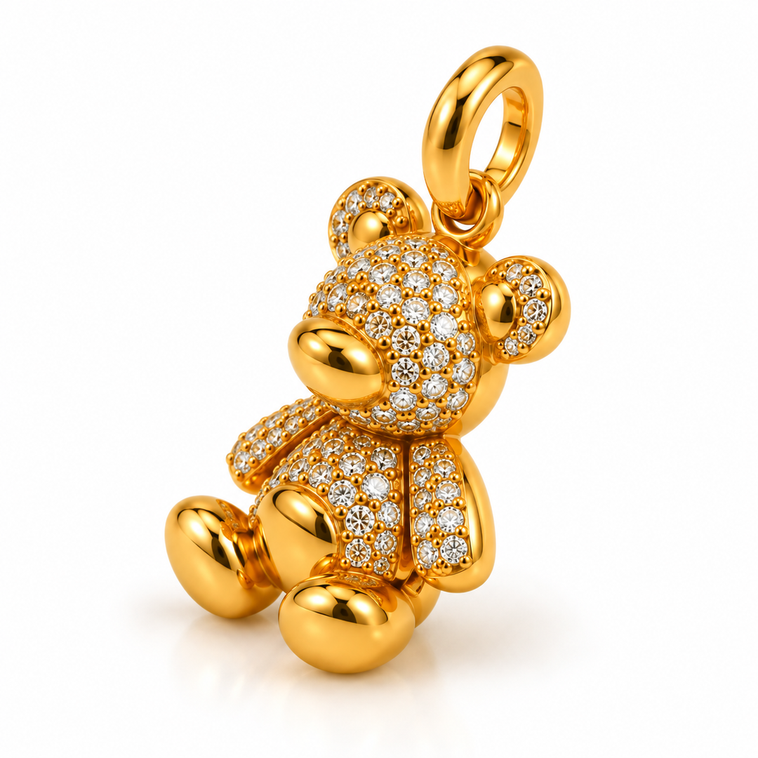A gold teddy bear pendant embellished with pavé-set clear stones, shown on a clean white background.