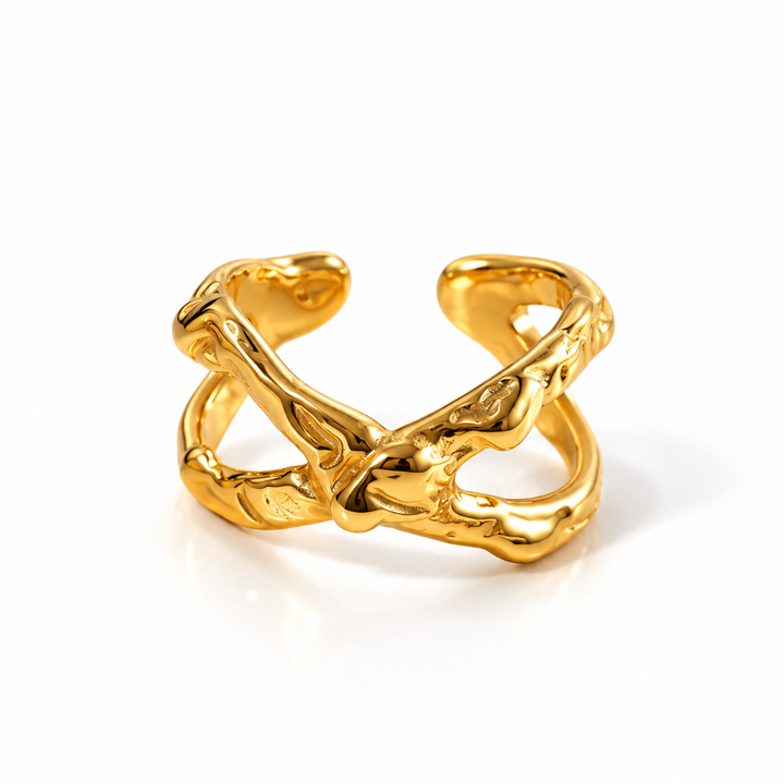 A polished gold abstract open cuff ring with a textured, organic, tree-like branching design, photographed on a clean white background.