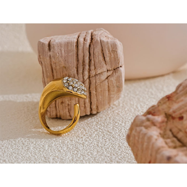 Gold ring with gemstones on a textured surface